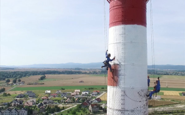 Ludzie na linach malują wysoki komin